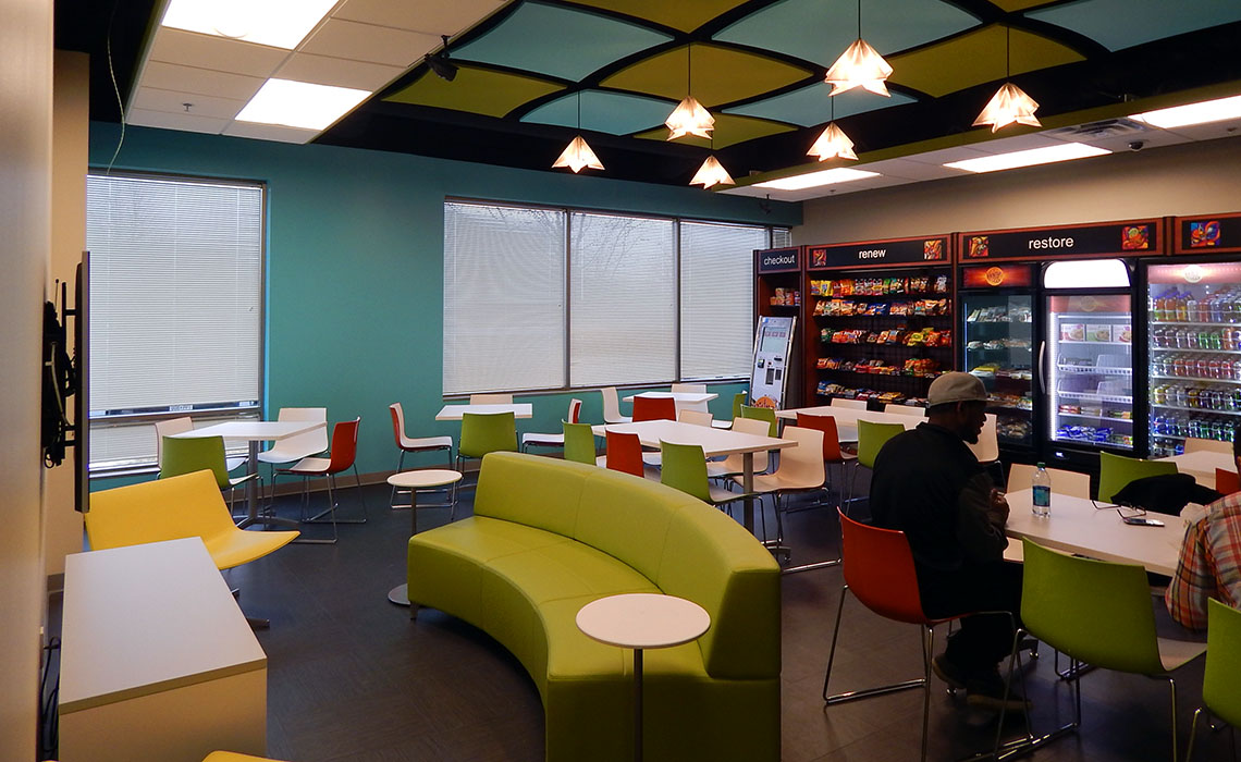 DirecTV's breakroom uses pops of color from furniture, tinted finishes, or even a dramatic, branded drop ceiling.