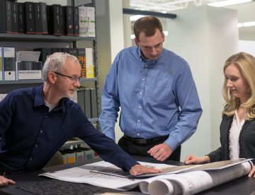 PlanForce designers and technicians examine architectural drawings